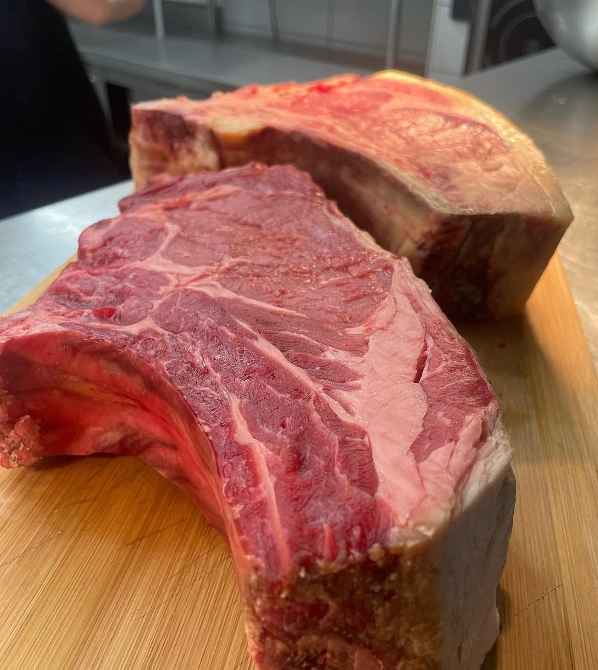 Deux pièces de bœuf crues sur planche en bois en cuisine